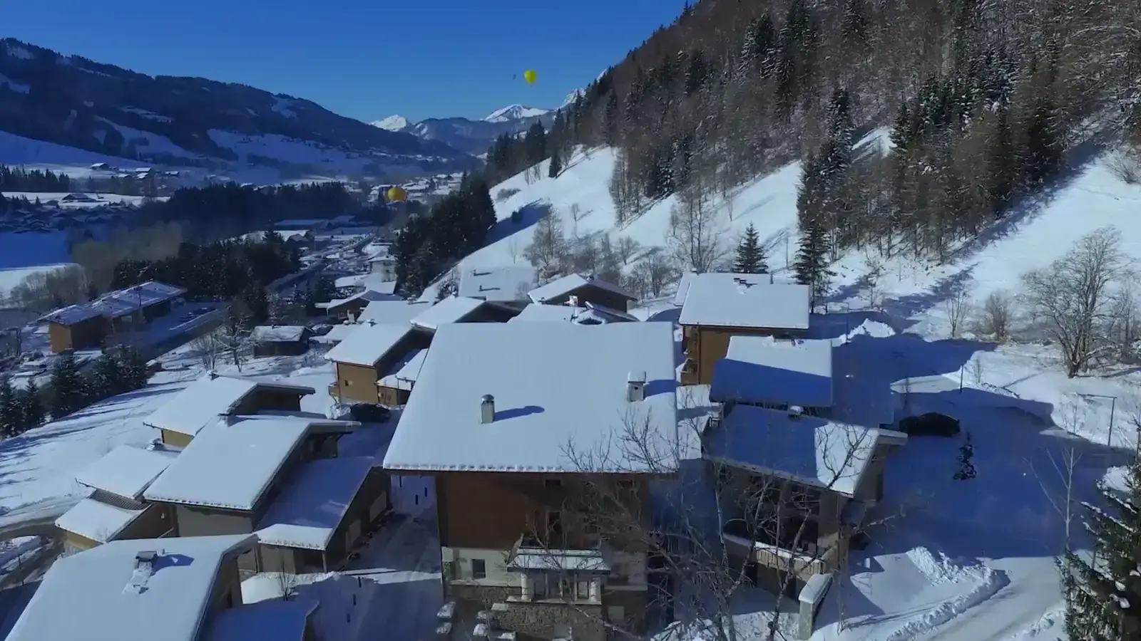 Le hameau des Portes de Megève sous la neige, au soleil couchant